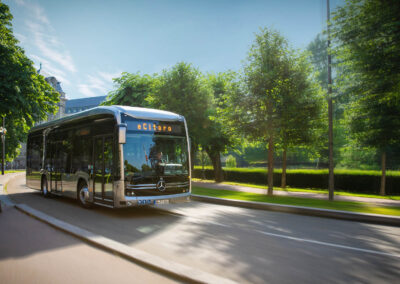 Elektrisk Mercedes-Benz eCitaro-buss från Daimler kör längs en grönskande stadsgata.