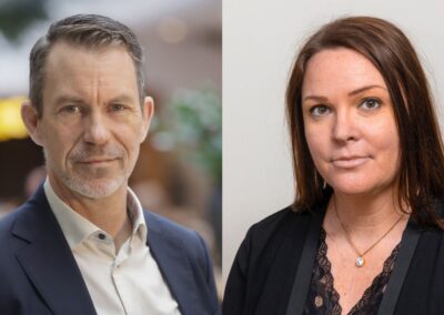 Porträttbilder sida vid sida av en man med kort gråbrunt hår och skägg, klädd i mörkblå kavaj och vit skjorta, samt en kvinna med långt brunt hår, svart kavaj och spetsblus.